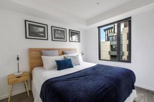 ein Schlafzimmer mit einem großen Bett und einem Fenster in der Unterkunft Beautiful 2BR APT with Balcony Pool and Gym in Melbourne