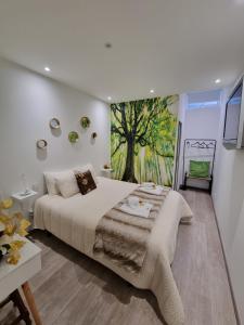 a bedroom with a large bed and a tree mural at Quinta do Ribeiro in Covilhã +18 photos