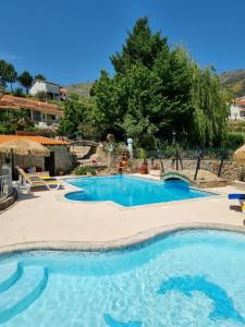 a swimming pool in a resort with blue water at Quinta do Ribeiro in Covilhã