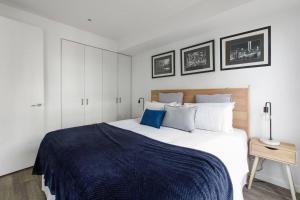 ein Schlafzimmer mit einem großen Bett mit einer blauen Decke in der Unterkunft Beautiful 2BR APT with Balcony Pool and Gym in Melbourne