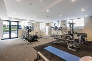 einen Fitnessraum mit Laufbändern und Trainingsgeräten in einem Gebäude in der Unterkunft Beautiful 2BR APT with Balcony Pool and Gym in Melbourne