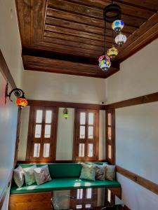 a living room with a green couch and some windows at Saffronia1900 Butik Otel in Safranbolu