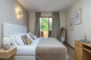 a bedroom with a large white bed and a window at Hotel Meandro - Lake View in Gargnano