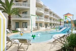 - une piscine avec des chaises et un toboggan dans l'établissement Iberostar Selection Albufera Park All Inclusive, à Playa de Muro