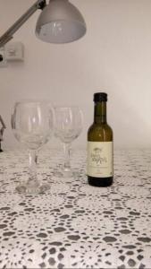 una botella de vino sentada en una mesa con copas de vino en Samos - Kokkari - Eirini's Studios en Kokkari