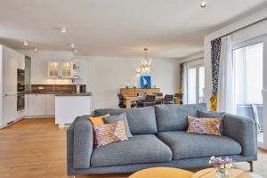 a living room with a blue couch and a kitchen at BergIdylle 2 in Garmisch-Partenkirchen