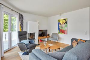 a living room with a blue couch and chairs at BergIdylle 2 in Garmisch-Partenkirchen