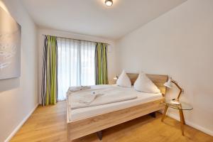 a bedroom with a bed with white sheets and a window at BergIdylle 2 in Garmisch-Partenkirchen