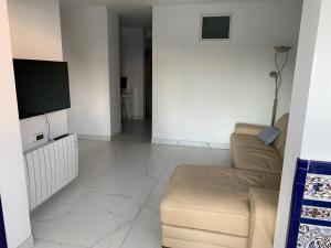a living room with a couch and a flat screen tv at Casa Cadi in Orihuela Costa