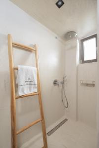 a bathroom with a shower with a towel on a ladder at Mnḗmē Suites & Villas in Kastrí