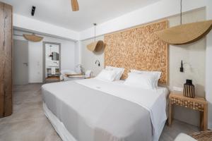 a bedroom with a large white bed in a room at Mnḗmē Suites & Villas in Kastrí