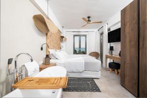 a hotel room with a bed and a bathroom at Mnḗmē Suites & Villas in Kastrí