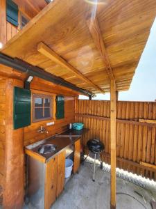 baño con lavabo y pared de madera en Unique wooden holiday house in nature, en Lukovica pri Domžalah