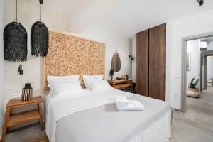 a bedroom with a large bed with white sheets at Mnḗmē Suites & Villas in Kastrí
