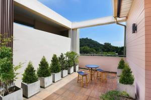 a patio with a table and chairs and potted plants at The Luxury Residence in Songkhla
