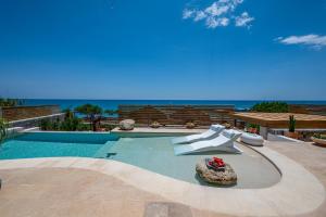 a swimming pool with a view of the ocean at Mnḗmē Suites & Villas in Kastrí