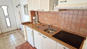 une cuisine avec des armoires blanches et un évier dans l'établissement Apartment Damijan, à Krk 38 autres photos