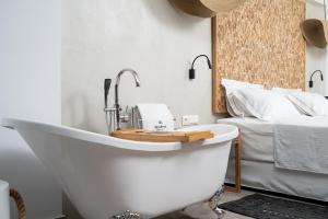 a bath tub in a bedroom with a bed at Mnḗmē Suites & Villas in Kastrí