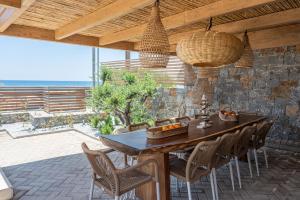 a dining room with a wooden table and chairs at Mnḗmē Suites & Villas in Kastrí