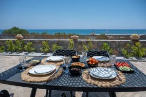 a table with plates and bowls of food on it at Mnḗmē Suites & Villas in Kastrí