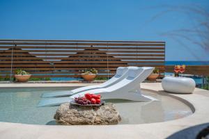 a pool with a white bench and a rock at Mnḗmē Suites & Villas in Kastrí