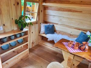 Cabaña de madera con mesa y ventana en Unique wooden holiday house in nature, en Lukovica pri Domžalah