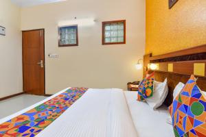 a bedroom with a large bed with a colorful comforter at FabHotel Royal Residency in Jaipur