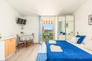 a bedroom with a blue bed and a balcony at Apartments Daniela in Makarska