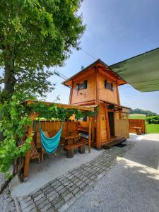 una casa en el árbol con una hamaca y un banco en Unique wooden holiday house in nature, en Lukovica pri Domžalah