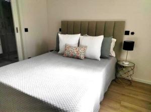 a bedroom with a large bed with white pillows at Flat moderno e central em Braga in Braga