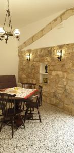 comedor con mesa y pared de piedra en Casa di Sissi en Monterosso Almo