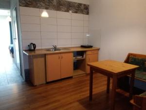uma cozinha com um lavatório e uma mesa de madeira em Apartamenty 3D em Giżycko