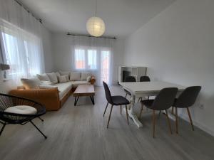 a living room with a couch and a table and chairs at Red Hill apartment in Zaboric