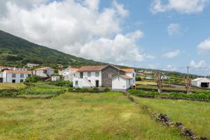 a village with houses and a grass field at Prainha Apartments in São Roque do Pico