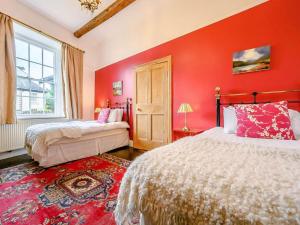 a red bedroom with two beds and a window at Oak Lodge in Keswick