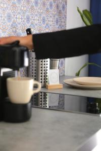 una persona está haciendo una taza de café en un mostrador en Arbio I Urbanstay Serviced Studios & Apartments en Graz