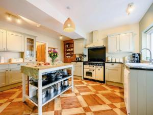 cocina grande con armarios blancos y encimera en Oak Lodge, en Keswick