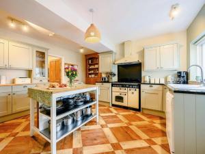 a large kitchen with white cabinets and a counter top at Oak Lodge in Keswick
