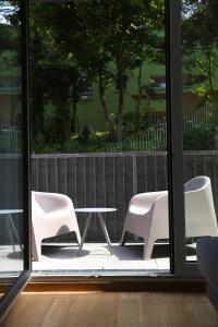 2 sillas blancas y una mesa en el patio en Arbio I Urbanstay Serviced Studios & Apartments en Graz