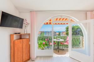 uma sala de estar com uma porta aberta para uma varanda em Apartments Daniela em Makarska