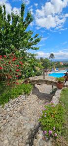 a garden with flowers and a swimming pool at Quinta do Ribeiro in Covilhã
