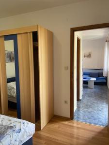 uma sala com uma porta aberta para um quarto em Apartmani Ksenija em Murter