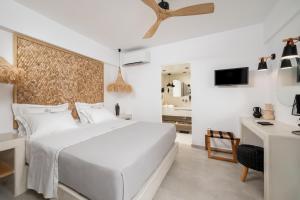 a bedroom with a large white bed and a desk at Mnḗmē Suites & Villas in Kastrí