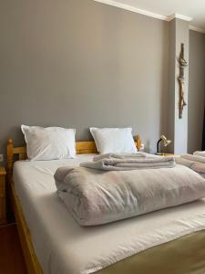 uma cama grande com lençóis brancos e almofadas em 2 Bedroom Apartment City em Blagoevgrad