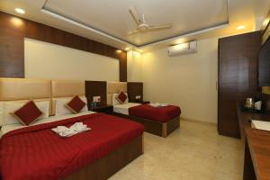 a hotel room with two beds with red sheets at Hotel Ld Prime in Jaipur