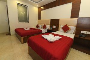 a hotel room with two beds with red sheets at Hotel Ld Prime in Jaipur