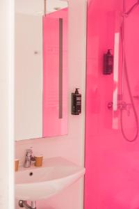 a bathroom with a pink shower and a sink at ibis Styles St Gilles Croix de Vie centre-ville in Saint-Gilles-Croix-de-Vie