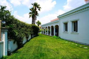 a yard in front of a white building with a palm tree at Luxury Villa Narlıdere in Narlıdere