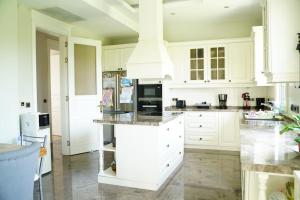 a kitchen with white cabinets and a large island at Luxury Villa Narlıdere in Narlıdere