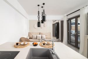 a kitchen with a sink and a living room at Mnḗmē Suites & Villas in Kastrí
